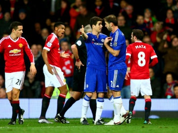 Jugadores del Chelsea y del Manchester United protestan una decisión del árbitro