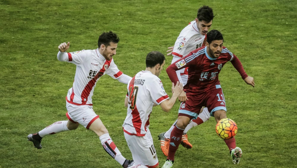 Carlos Vela conduce el balón ante la defensa del Rayo Vallecano