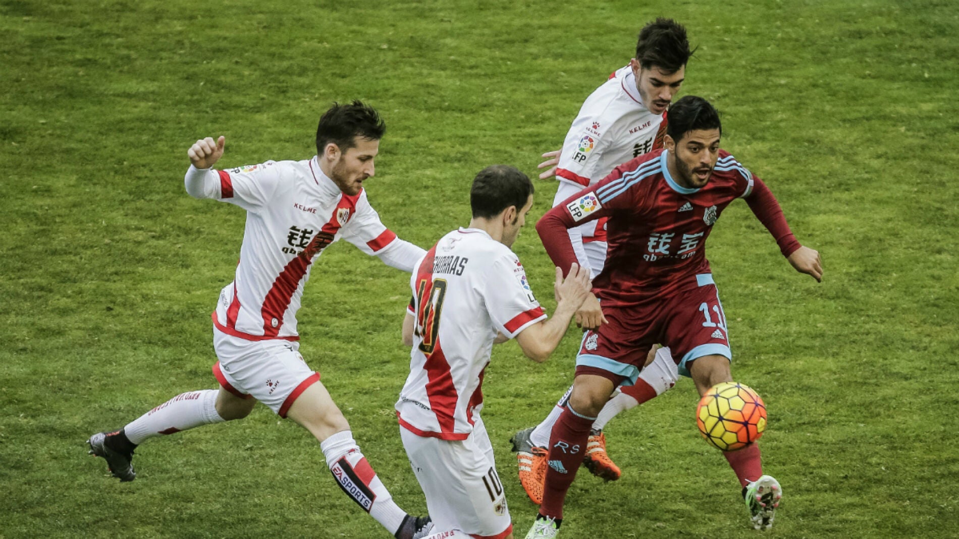 Carlos Vela conduce el bal&oacute;n ante la defensa del Rayo Vallecano