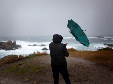 Un hombre ve como el viento le dobla el paraguas en A Coruña