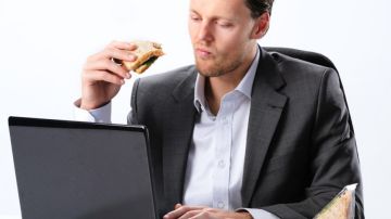 Un hombre comiendo un bocadillo en el trabajo