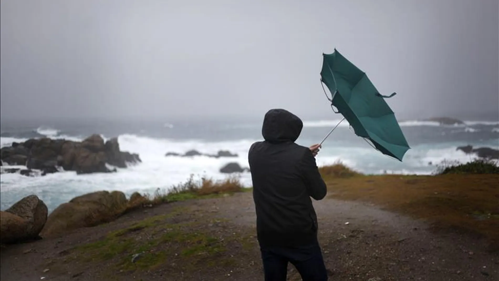Un hombre ve cómo el viento le dobla el paraguas en A Coruña Un hombre ve cómo el viento le dobla el paraguas en A Coruña