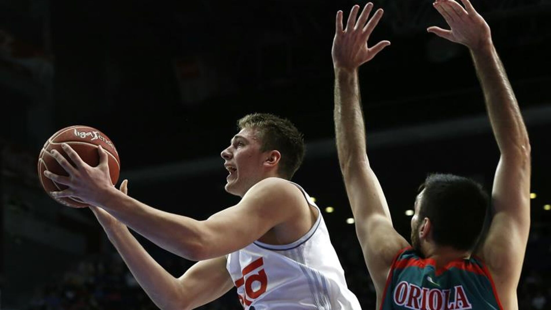  El base esloveno del Real Madrid, Luka Doncic (i), supera al alero del Baloncesto Sevilla, Pierre Oriola (d)