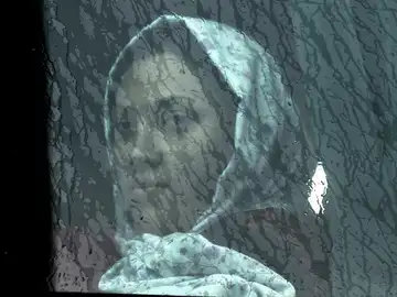 Una mujer inmigrante mira a través de la ventana Una mujer inmigrante mira a través de la ventana