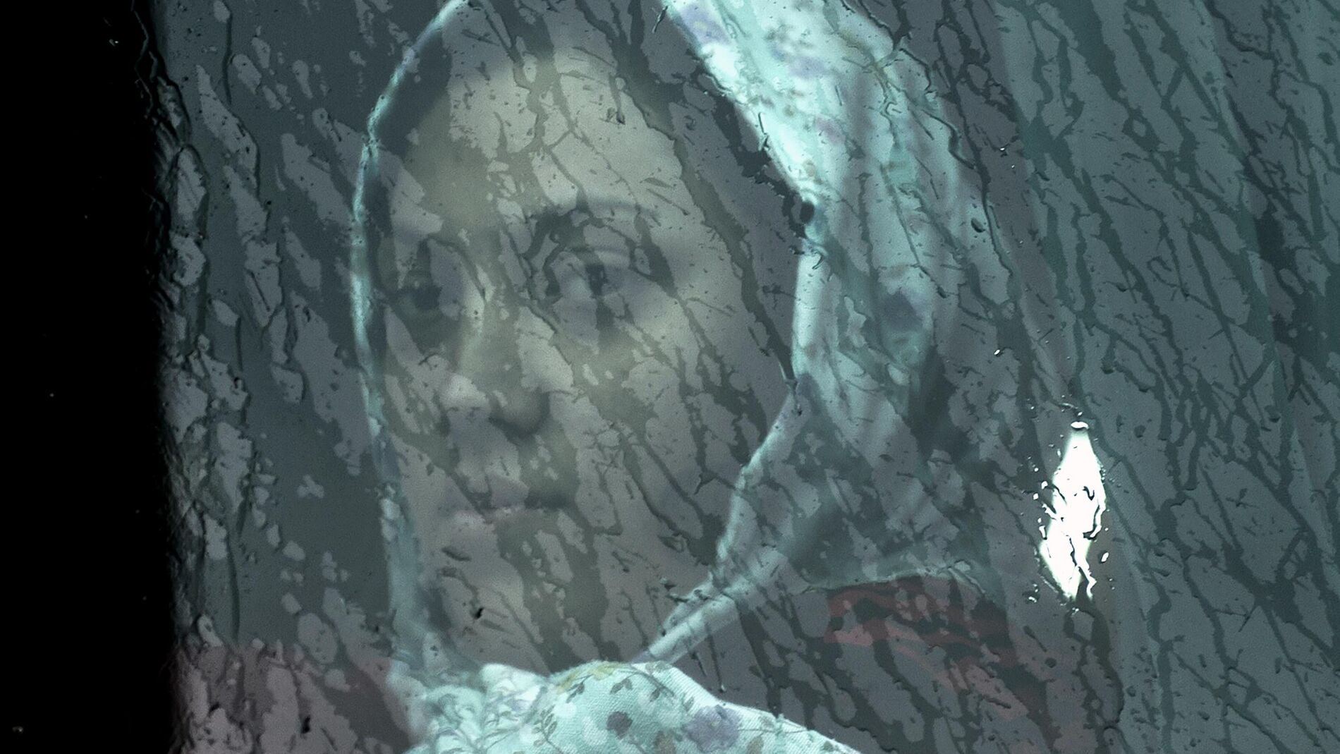 Una mujer inmigrante mira a trav&eacute;s de la ventana