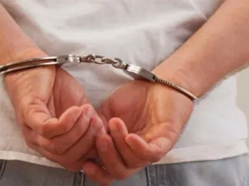 Un hombre detenido y esposado Un hombre detenido y esposado