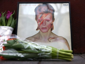 Homenaje a David Bowie frente al mural del cantante en Londres