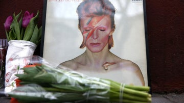 Homenaje a David Bowie frente al mural del cantante en Londres