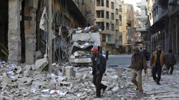 Varias personas caminan entre los escombros a las afueras de Damasco