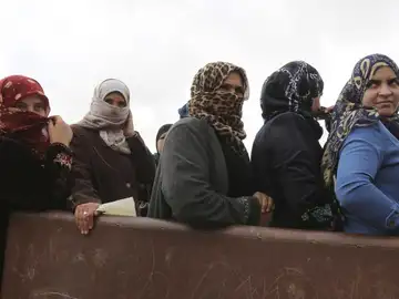 Un grupo de refugiadas sirias esperan ayuda en un campo Un grupo de refugiadas sirias esperan ayuda en un campo