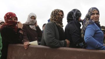 Un grupo de refugiadas sirias esperan ayuda en un campo