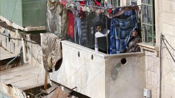 Palestinos observan una evacuación desde el balcón de su casa