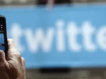 Un hombre fotografía el logo de Twitter Un hombre fotografía el logo de Twitter