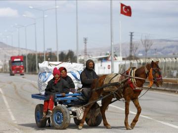 Refugiados viajan este domingo entre la frontera turco-siria.