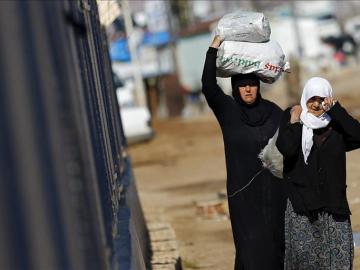 Refugiados sirios trasladan bolsas de alimentos en el paso fronterizo de Öncüpinar, en Kilis, 