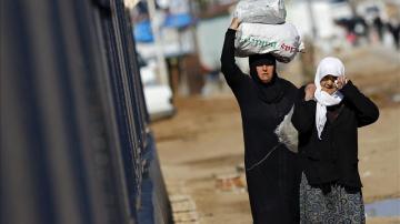 Refugiados sirios trasladan bolsas de alimentos en el paso fronterizo de Öncüpinar, en Kilis, 