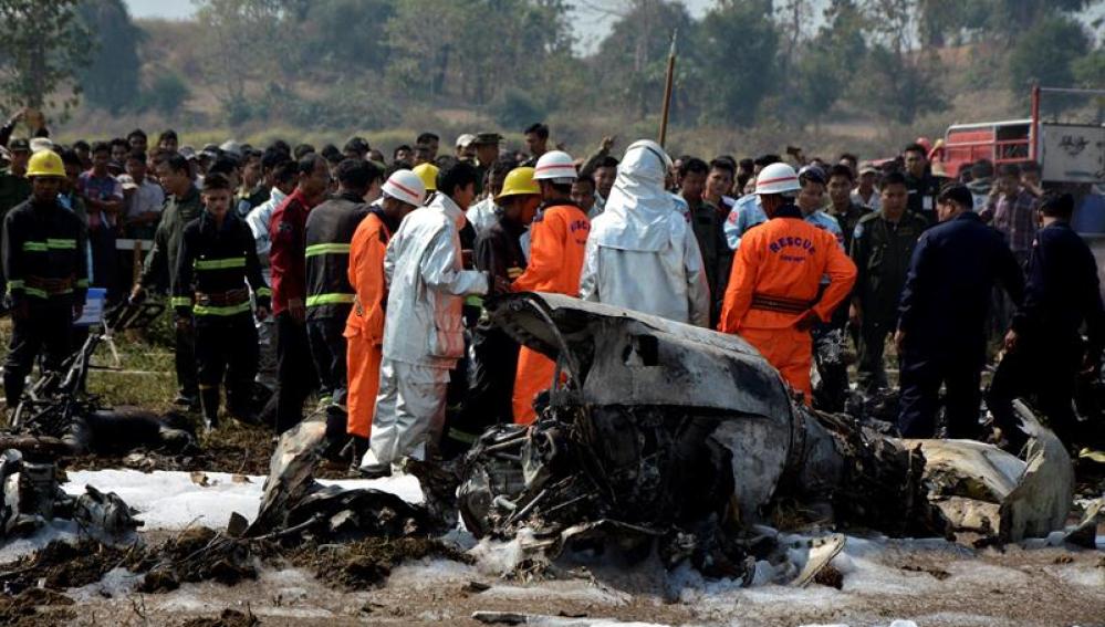Bomberos y miembros de los servicios de rescate inspeccionan los restos de un avión militar siniestrado