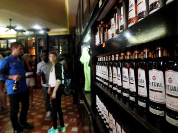 Turistas observan varias botellas de ron en La Habana