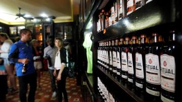 Turistas observan varias botellas de ron en La Habana