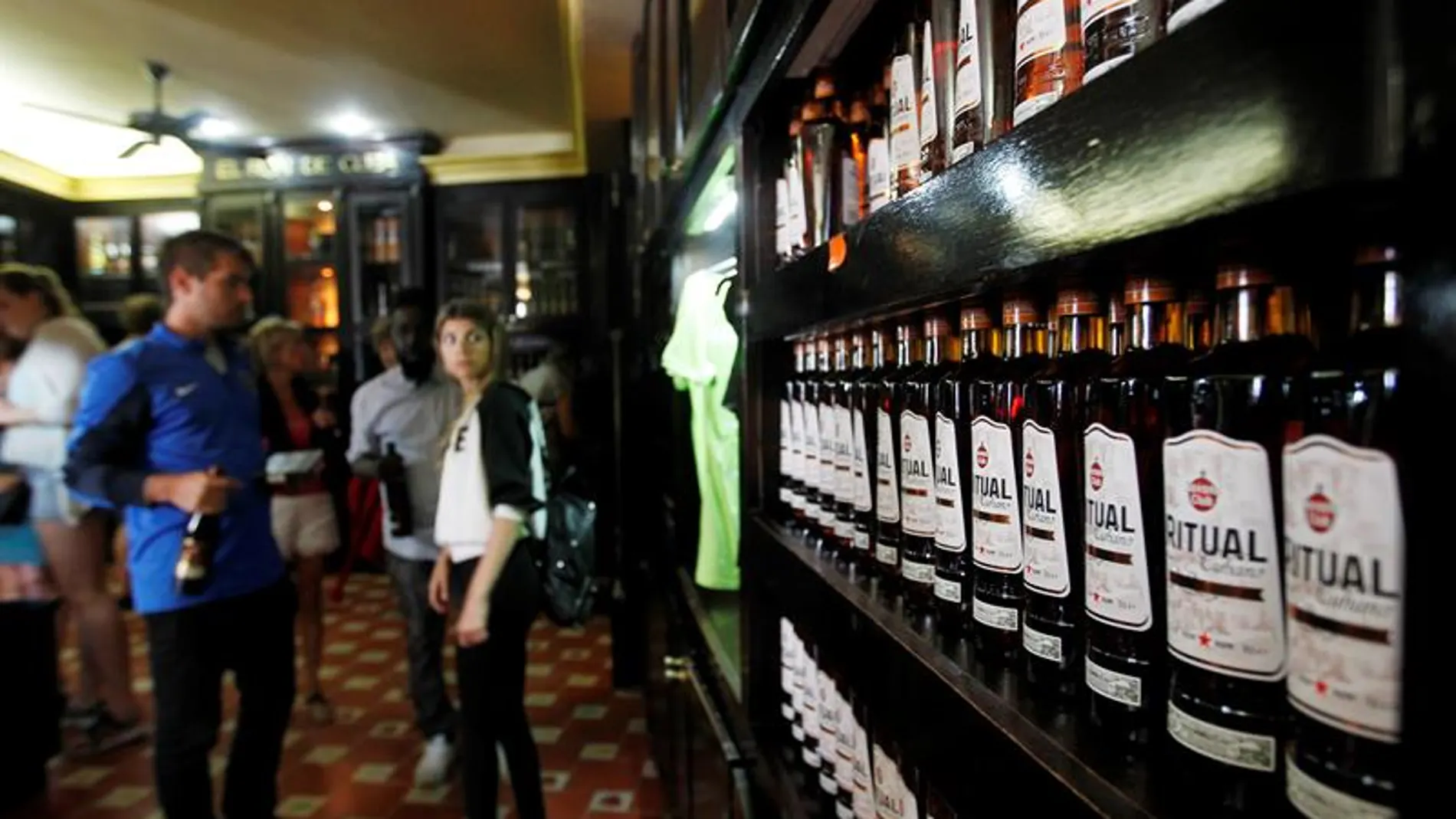 Turistas observan varias botellas de ron en La Habana Turistas observan varias botellas de ron en La Habana
