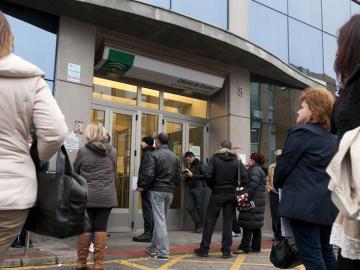 Personas esperan a las puertas de una oficina de empleo