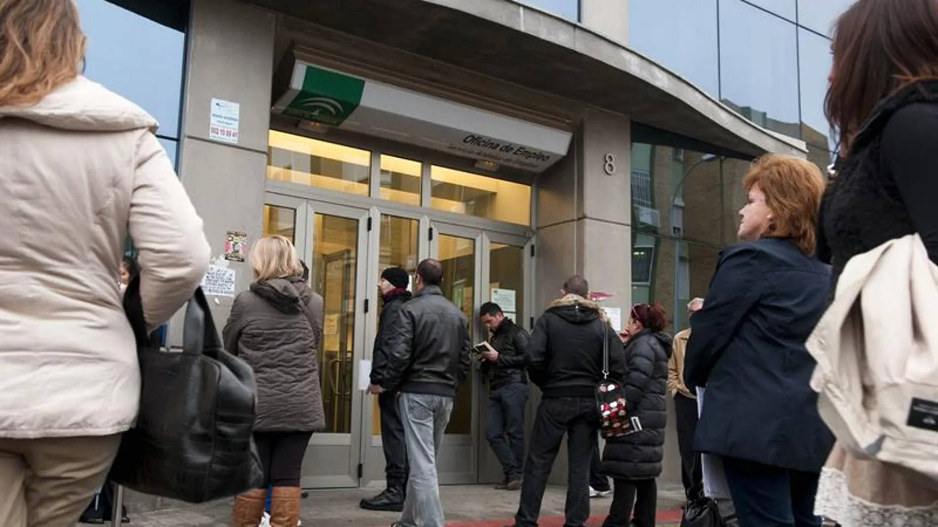 Personas esperan a las puertas de una oficina de empleo Personas esperan a las puertas de una oficina de empleo