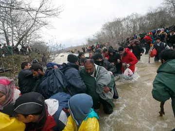 Los refugiados han cruzado un río para atravesar la frontera Los refugiados han cruzado un río para atravesar la frontera