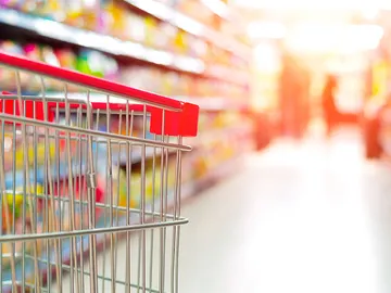 Un carro en un pasillo de un supermercado Un carro en un pasillo de un supermercado