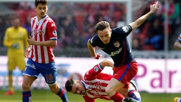 Saúl pelea el balón ante los defensores del Sporting de Gijón