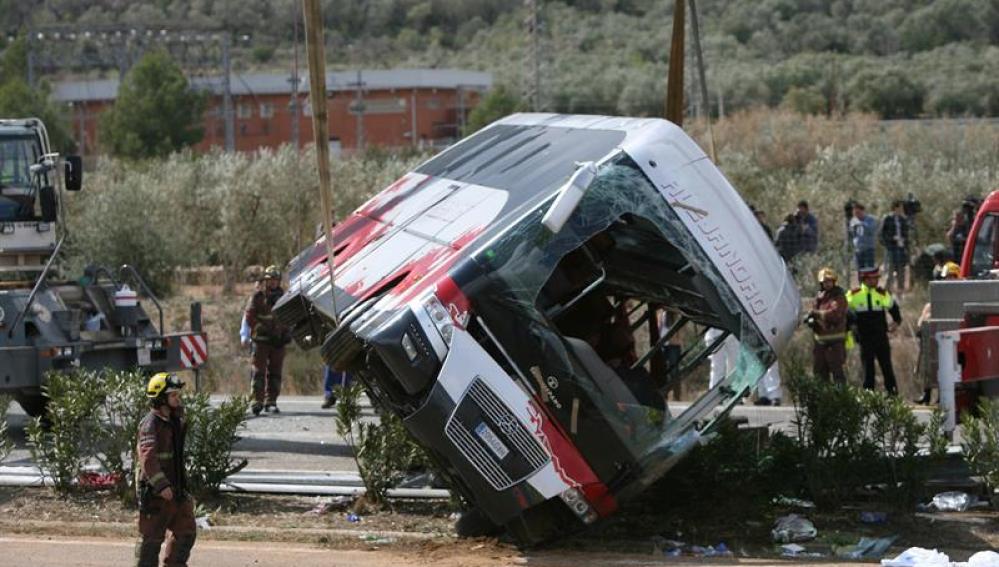 Efectivos del cuerpo de bomberos en el momento de levantar el autocar 