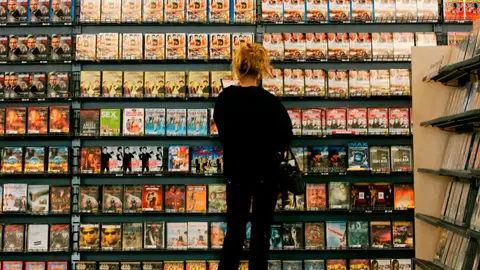 Una mujer alquilando una película en un videoclub Una mujer alquilando una película en un videoclub