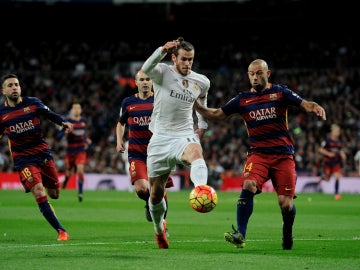 Gareth Bale conduce el balón ante la presión del Barcelona