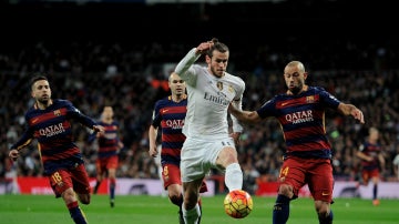 Gareth Bale conduce el balón ante la presión del Barcelona