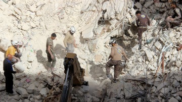 Miembros de los equipos de rescate buscan entre los escombros