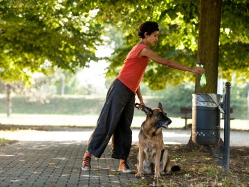 Mujer recogiendo las cacas de su perro