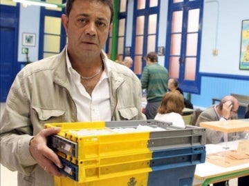 Un empleado de Correos entregando los votos en un colegio electoral 