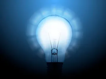 Imagen de una bombilla sobre fondo azul Imagen de una bombilla sobre fondo azul