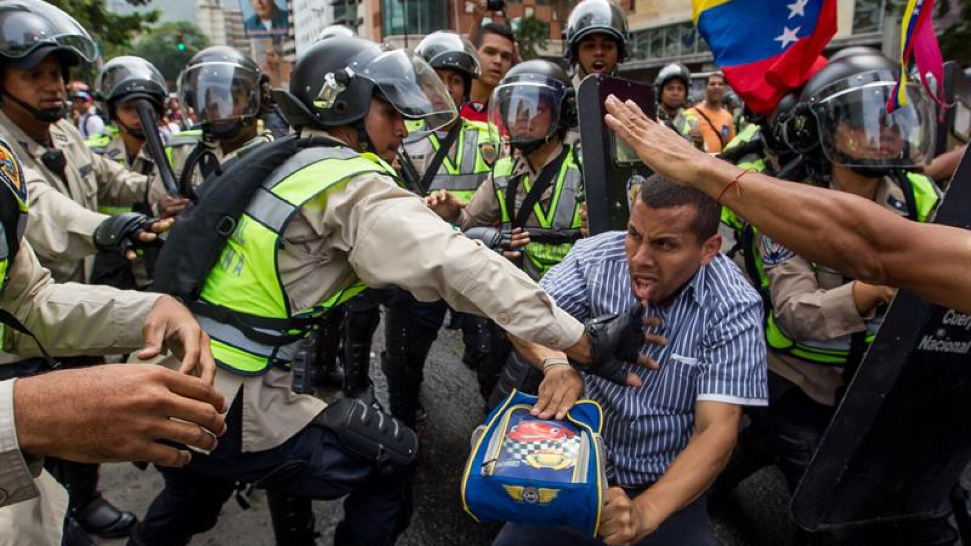  Miembros de la Polic&iacute;a Nacional Bolivariana forcejean con un manifestante 