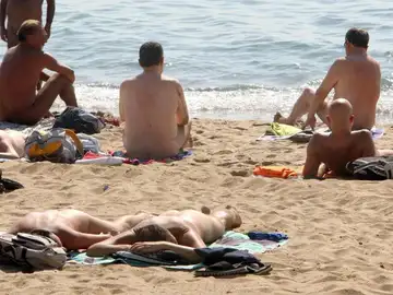 Varias personas practican nudismo en una playa Varias personas practican nudismo en una playa