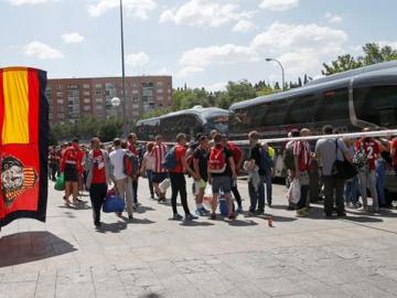 Los aficionados del Atlético esperan para subirse al autobús que les lleva a Milán