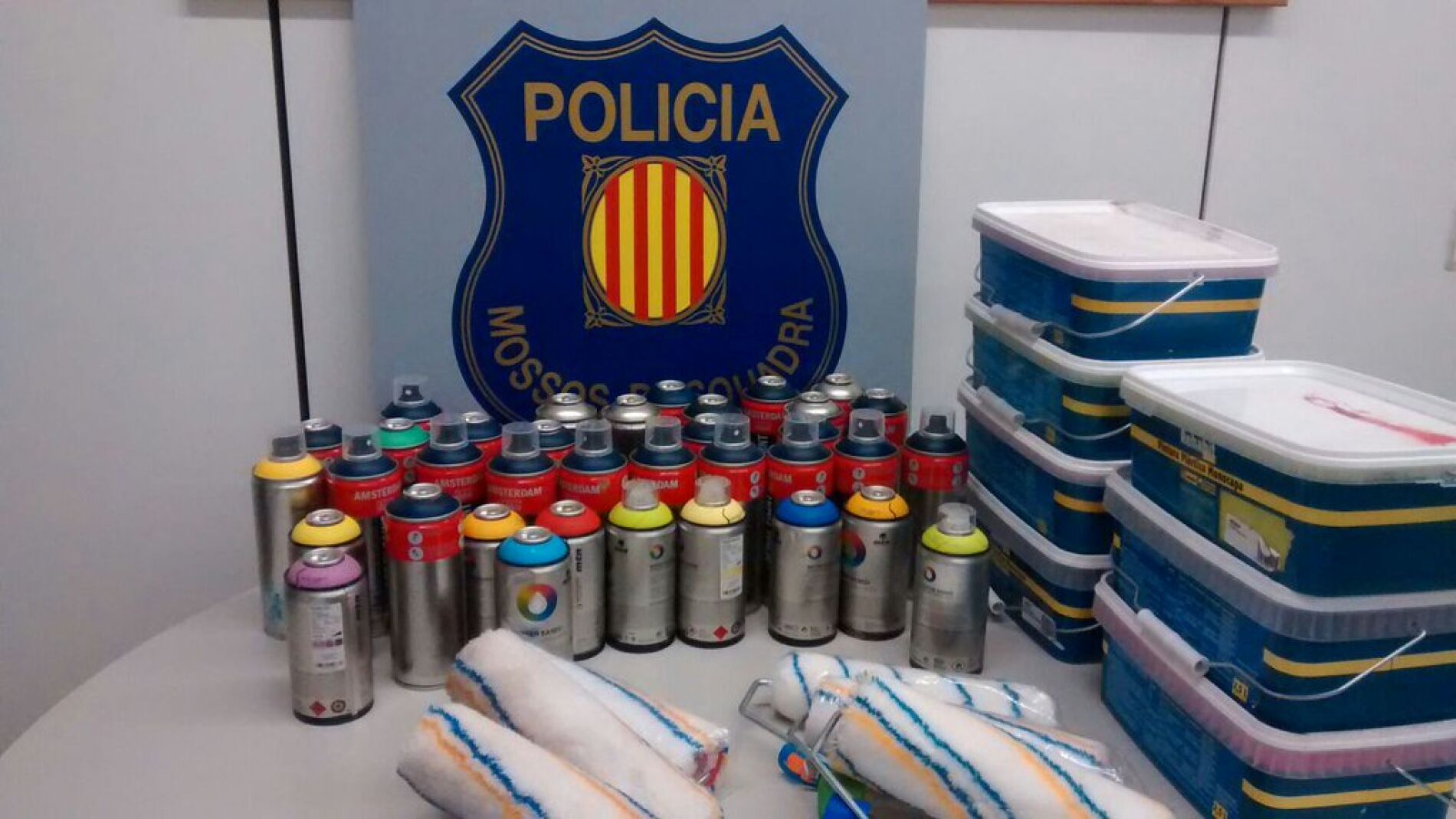 Botes de espr&aacute;is, pinturas y rodillos intervenidos