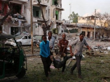 Cuatro hombres evacuan a un herido por el atentado en el Hotel Ambassador de Mogadiscio Cuatro hombres evacuan a un herido por el atentado en el Hotel Ambassador de Mogadiscio