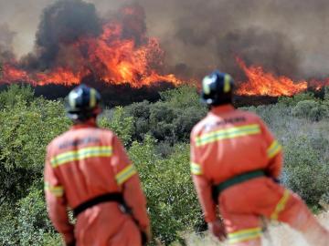 Dos bomberos observan las llamas cerca de la localidad de Sumacarcer (Valencia) Dos bomberos observan las llamas cerca de la localidad de Sumacarcer (Valencia)