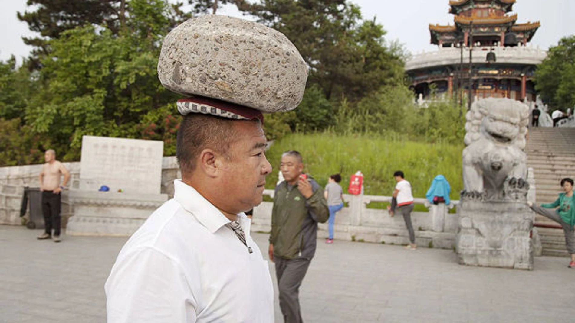 Cong Yan caminando con una piedra en la cabeza Cong Yan caminando con una piedra en la cabeza