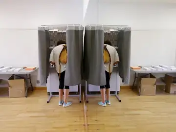 Un elector con su imagen reflejada en un espejo elige su papeleta para ejercer su derecho al voto en el Centro Cultural Volturno, en la localidad madrileña de Pozuelo de Alarcón. Un elector con su imagen reflejada en un espejo elige su papeleta para ejercer su derecho al voto en el Centro Cultural Volturno, en la localidad madrileña de Pozuelo de Alarcón.