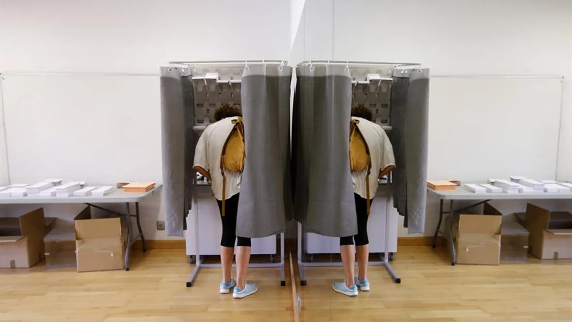 Un elector con su imagen reflejada en un espejo elige su papeleta para ejercer su derecho al voto en el Centro Cultural Volturno, en la localidad madrileña de Pozuelo de Alarcón. Un elector con su imagen reflejada en un espejo elige su papeleta para ejercer su derecho al voto en el Centro Cultural Volturno, en la localidad madrileña de Pozuelo de Alarcón.