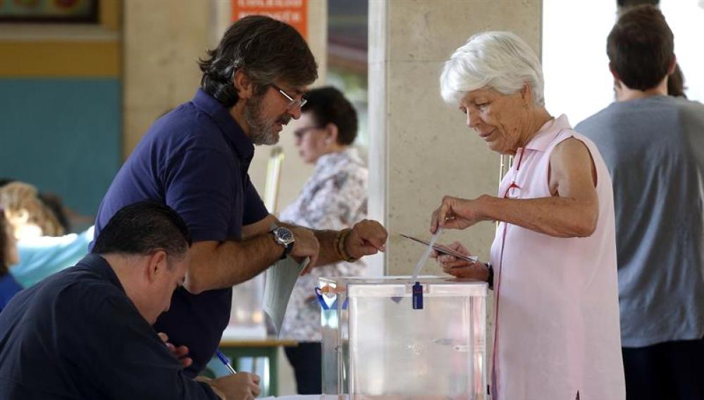 Una mujer deposita su voto en una urna de un colegio electoral