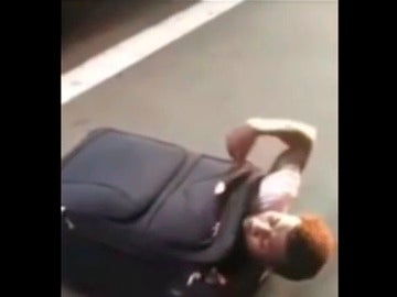 El joven intentando salir de su maleta.
