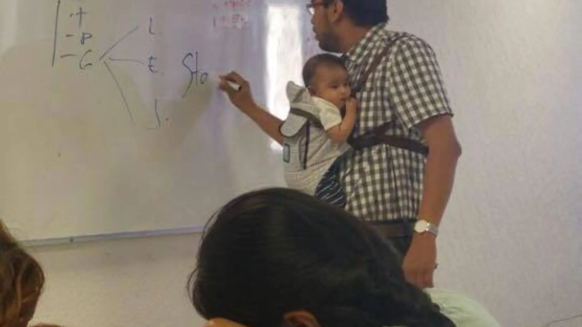 Profesor con el bebé cogido Profesor con el bebé cogido
