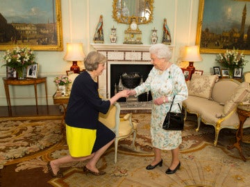 Theresa May hace una reverencia ante la Reina Isabel II